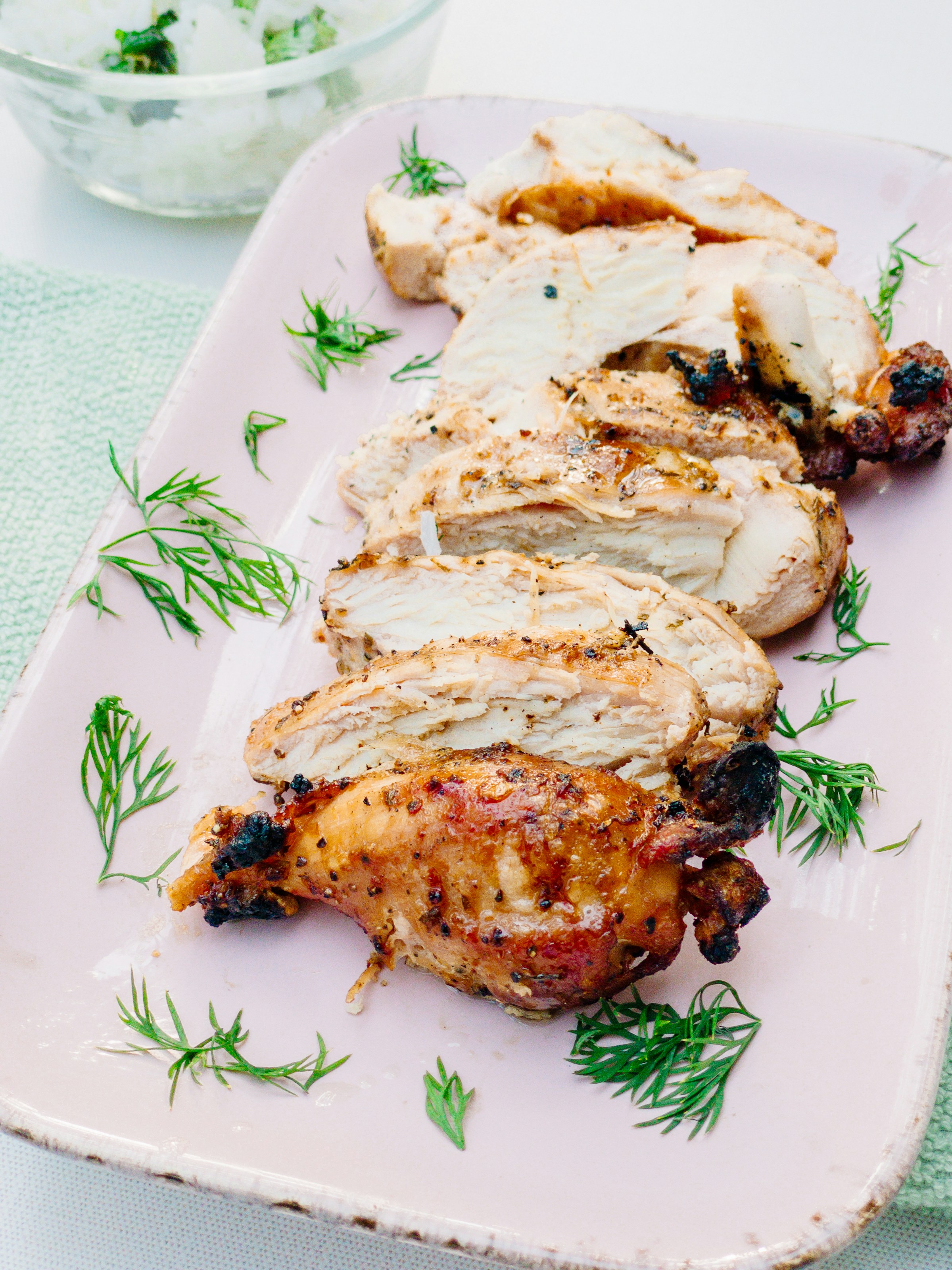 Grilled chicken plated with sauce and vegetables